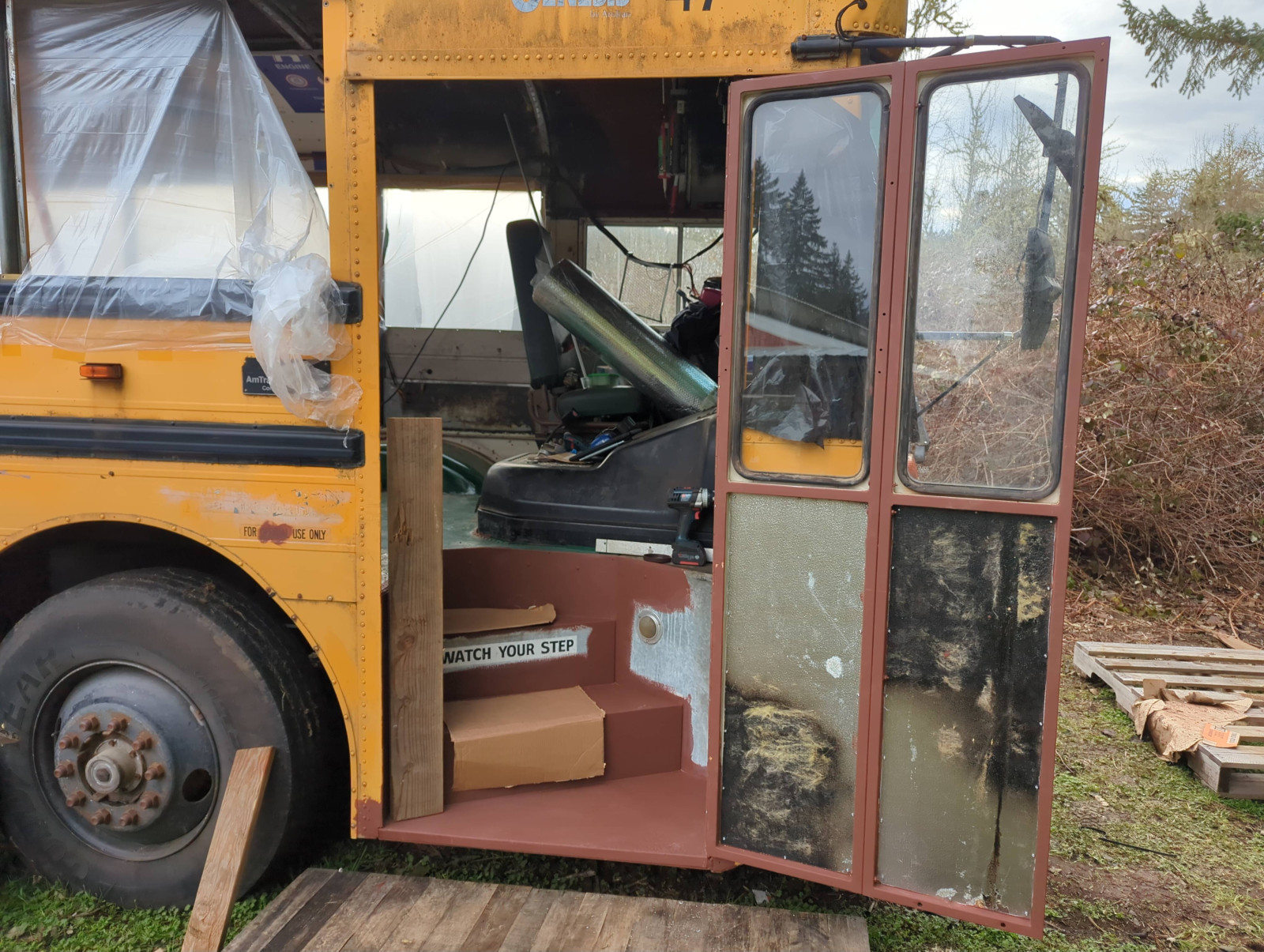 <p>The door was originally an accordion fold like the standard old-school bus. I took it off, flipped the hinges upside down and bolted the two halves of it together to make it a solid piece. Add a deadbolt and a couple deer antler handles...</p>